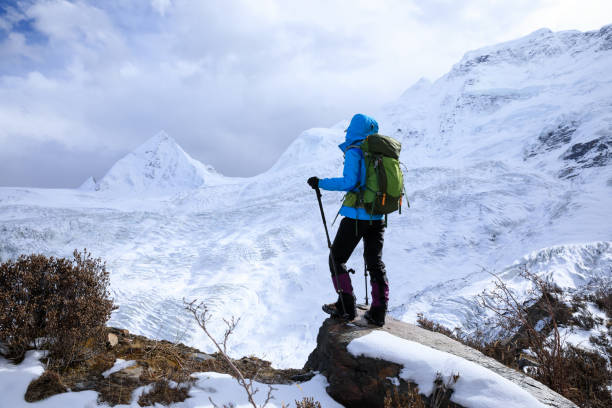 istock Successful woman backpacker hiking in winter mountains 1318564852