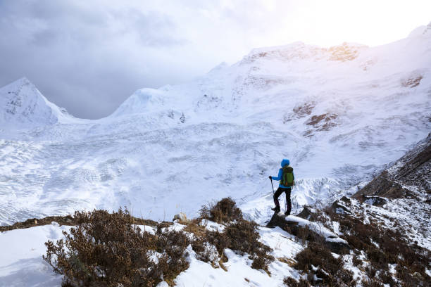 istock Successful woman backpacker hiking in winter mountains 1318564886