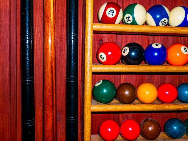 istock Colored billiard balls and a cue on a wooden shelf. 1318570185