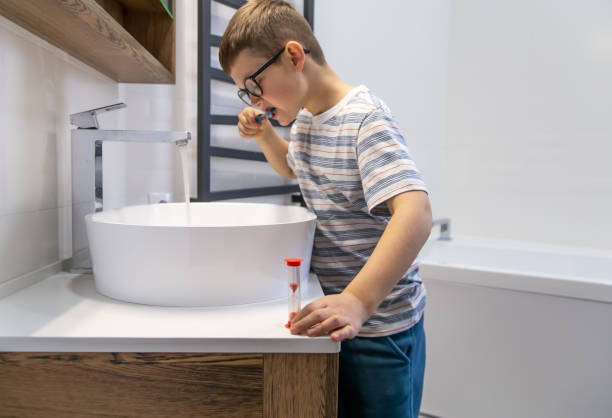 istock A little boy with glasses in the bathroom brushes his teeth. 1318573008