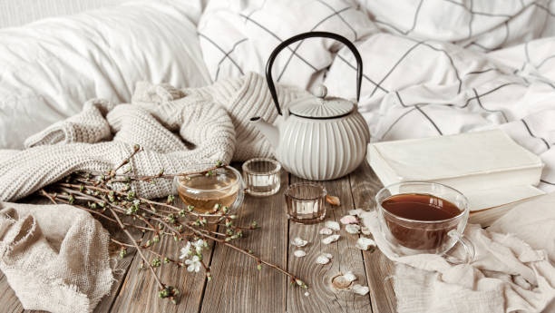 istock Cozy home composition with a cup of tea, spring branches and a knitted element. 1318573028