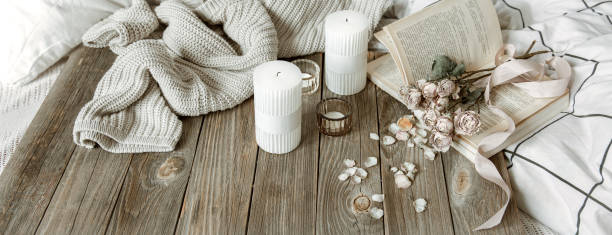 istock Cozy home composition with book, candles and knitted element. 1318573035