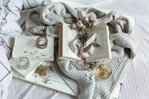 istock Cozy home composition with book, flowers and knitted element. 1318573042