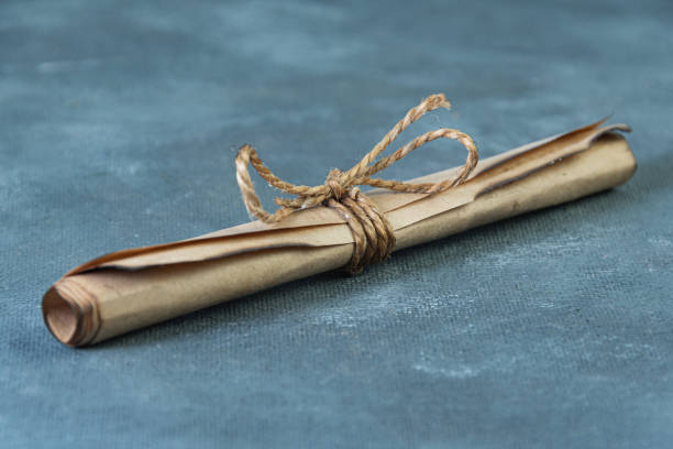 istock Old paper scroll is tied with jute rope 1318573485