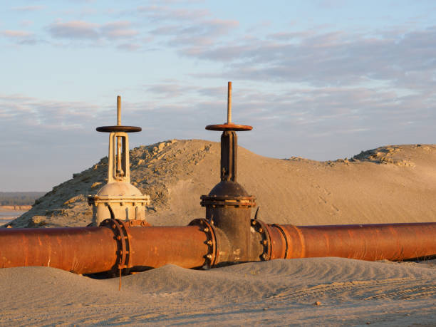 un viejo oleoducto oxidado en el desierto con válvulas. oleoducto para petróleo o gas al amanecer. minería de recursos naturales - valve air valve oil field oil fotografías e imágenes de stock