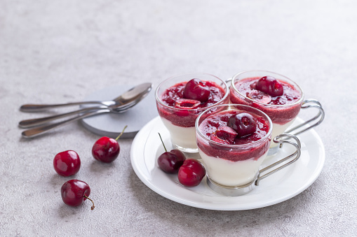 Homemade cherry mousse in a glass on a concrete board