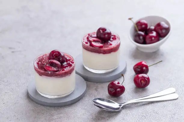 Homemade cherry mousse in a glass on a concrete board