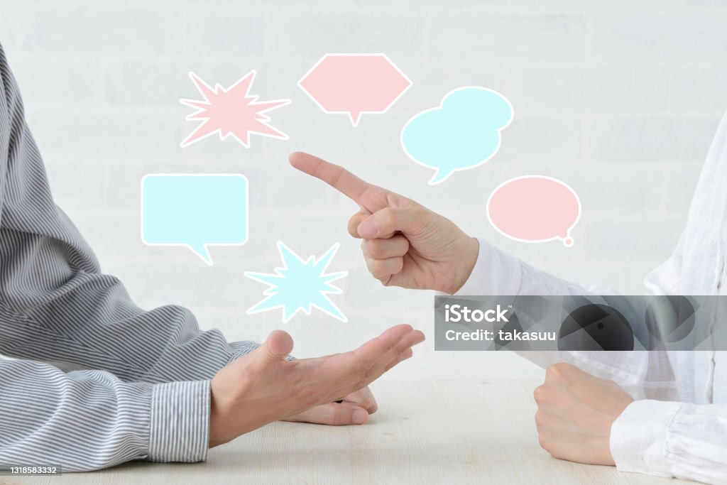 Man and woman's hands in qurrel with speech bubbles Conflict Stock Photo