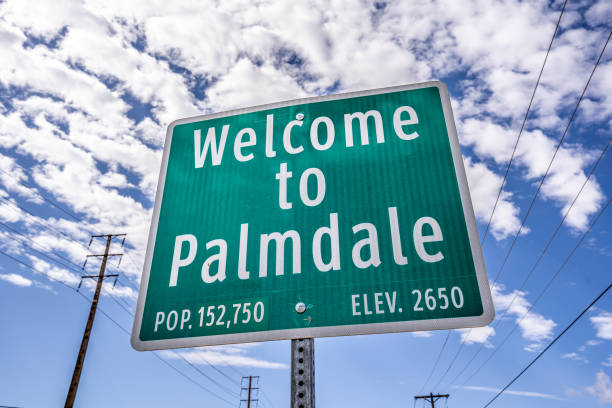 kuvapankkikuvat ja rojaltivapaat kuvat aiheesta tervetuloa palmdale green city -kylttiin, jossa on väestön sininen taivas pilvillä ja voimalinjoilla - lancaster california