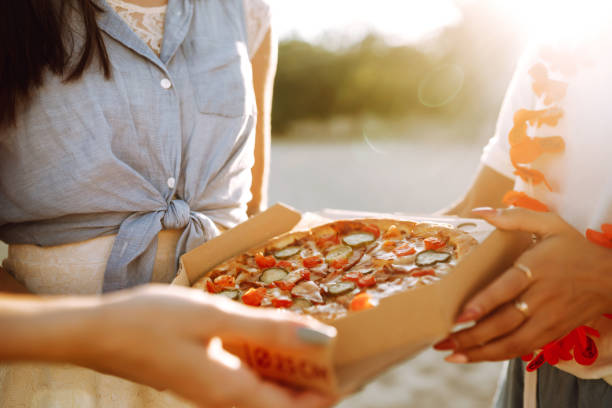 istock Hands taking slices of pizza close view. 1318588001