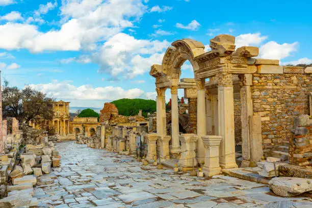 View of remained architectural elements of buildings and statues on main street of Curetes in Ephesus in winter day, Izmir province, Turkey