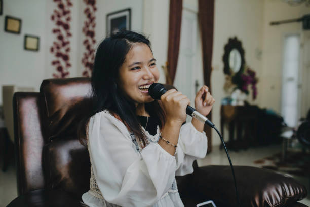 istock Young woman singing karaoke 1318588506