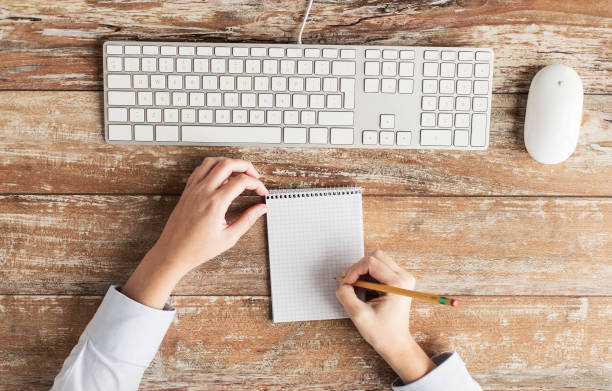 istock close up of hands with notebook and keyboard 1318589794