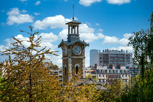 Closeup on the old clock tower of Georges Brassens Public Park in Paris, France.