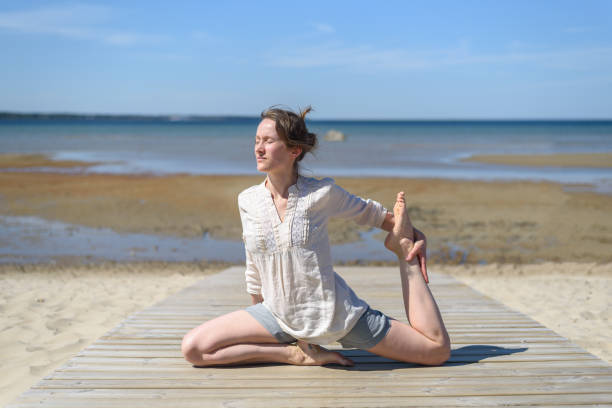 istock Woman doing yoga poses on beach 1318594512