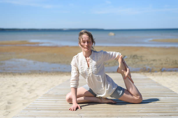 istock Woman doing yoga poses on beach 1318594551