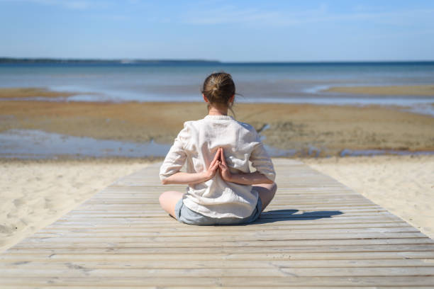 istock Woman doing yoga poses on beach 1318595211