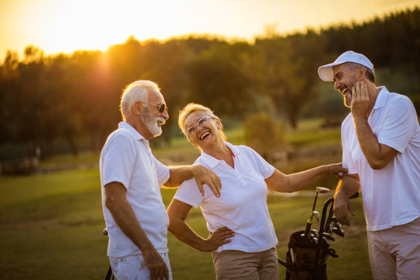 drei seniorengolfer sprechen auf dem golfplatz.  das war der perfekte tag für spaß. - retirement golfer happiness relaxation stock-fotos und bilder