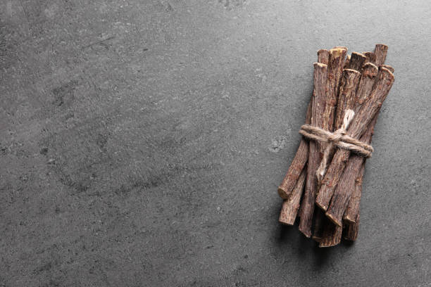 istock Dried sticks of liquorice root on grey table, top view. Space for text 1318596805