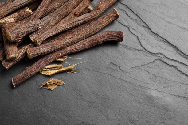 istock Dried sticks of liquorice root on black table, flat lay. Space for text 1318596839