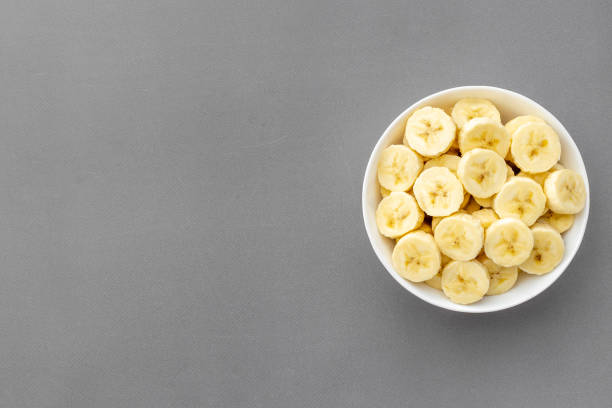 istock Many banana slices in white bowl. Top view 1318597795