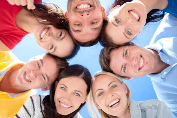 istock smiling friends in circle on summer beach 1318598049