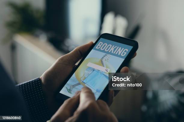 Man Books Online With His Smartphone Stock Photo - Download Image Now - Vacation Rental, Making a Reservation, Renting