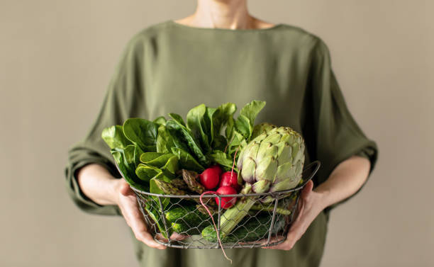 mujer sosteniendo una cesta llena de productos vegetales frescos, concepto de alimentos saludables - vegana fotografías e imágenes de stock