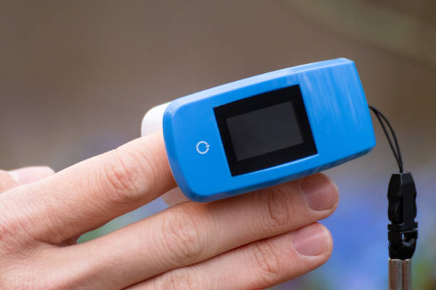 istock Pulse oximeter on finger close-up in blue flowers 1318602459