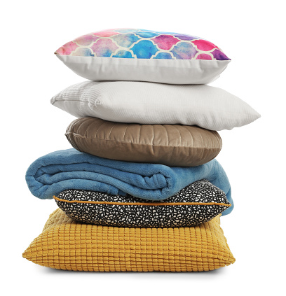 Stylish soft pillows and folded blanket on white background