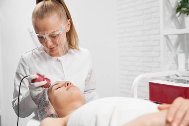 istock Procedure for face with special machine for young woman. 1318609635