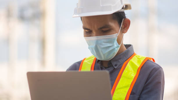 istock Engineer wear medical mask protect covid19 coronavirus and working outdoor computer technology 1318611058