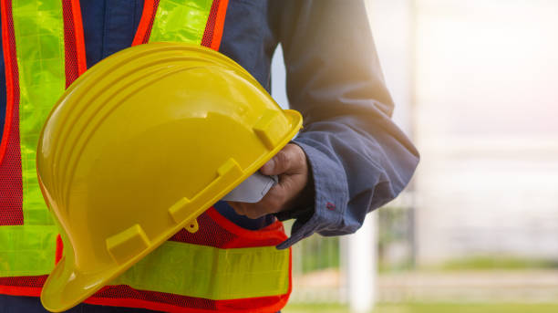 istock Technician holding Yellow hard hat safety hard hat sunlight background 1318611138