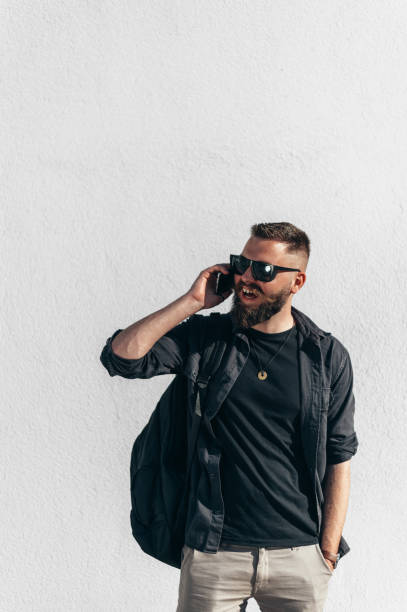 istock Young handsome man using a smartphone and wearing sunglasses outside 1318613459