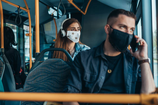 istock Woman wearing protective mask and using a headphones while riding a bus 1318613471