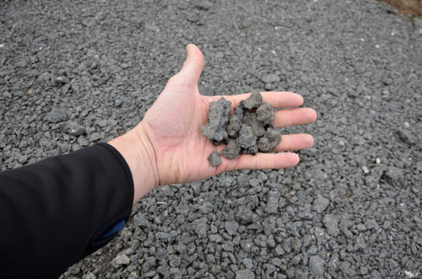 リサイクルアスファルトのパン粉は、新しいサイクルパスの端とアスファルト道路の地下に使用されます。フィールドと縁石の後ろのパスの間に駐車場。 - subsoil ストックフォトと画像