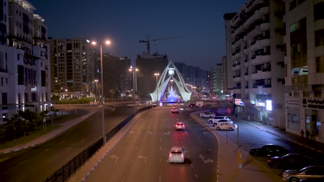 Deira clock tower roundabout and city street in old Dubai area at blue hour