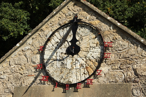 Amsterdam, Netherlands - May 15, 2018: White Sundial Clock With Gold Sun at Museum Garden Close up.