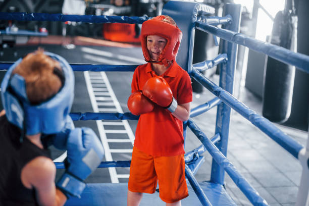 istock Two boys in protective equipment have sparring and fighting on the boxing ring 1318614974