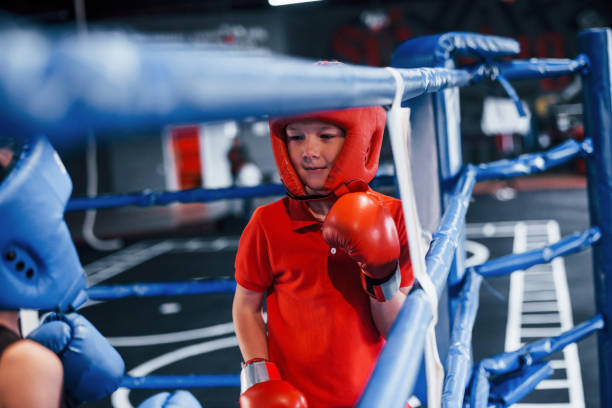 istock Two boys in protective equipment have sparring and fighting on the boxing ring 1318614992