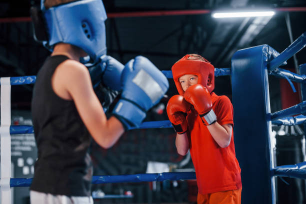 istock Two boys in protective equipment have sparring and fighting on the boxing ring 1318615031
