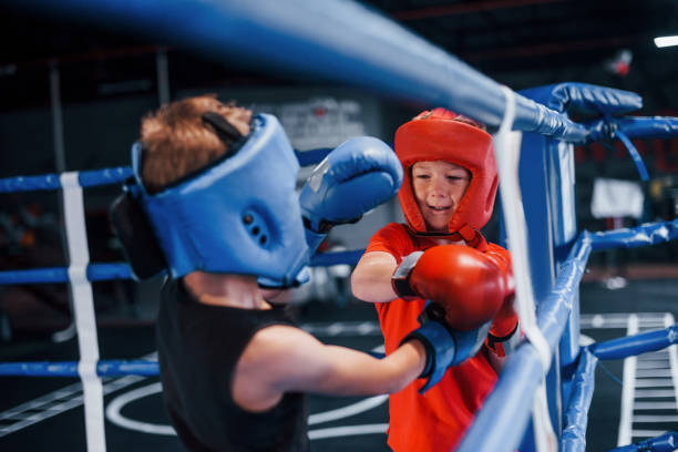 istock Two boys in protective equipment have sparring and fighting on the boxing ring 1318615065