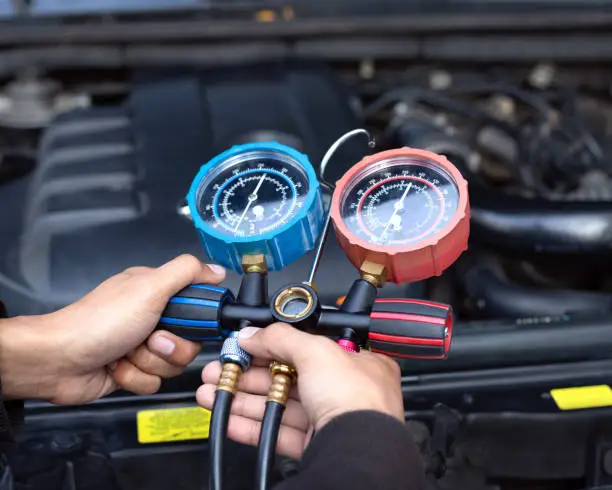 Photo of Car air conditioner check service, leak detection, fill refrigerant.Device and meter liquid cooling in the car by specialist technicians.