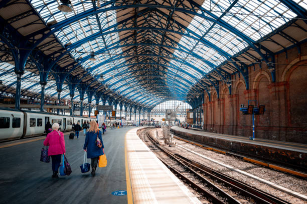 Brighton, UK - 17 May, 2021: color image depicting people walking on the railroad station platform, having just disembarked from their train, in Brighton, UK.