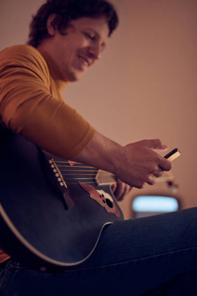 복고풍의 앰프에 어쿠스틱 기타를 연주하는 남성 음악가 - fingerstyle 뉴스 사진 이미지