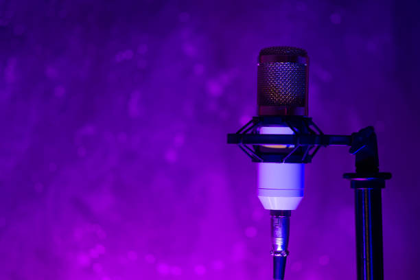 istock Studio condenser microphone on the stand, lots of copy space, color backlight. The concept of sound recording, podcast 1318620272