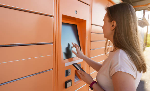 istock Woman picks up mail from automated self-service post terminal machine. 1318623622