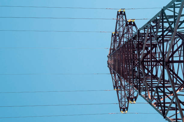 istock High voltage tower with electricity transmission power lines against blue sky, low angle view.Copy space. 1318625322