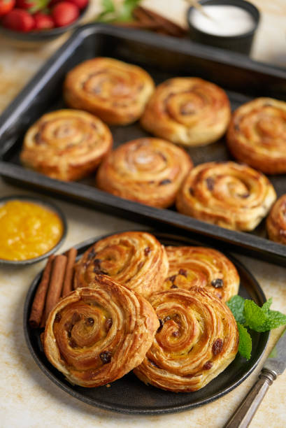 istock Delicious, fresh baked cinnamon buns served on black ceramic plate. With various sides 1318625381