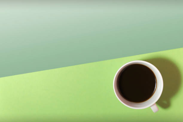 istock cup of coffee on a green and light green background top view 1318627892